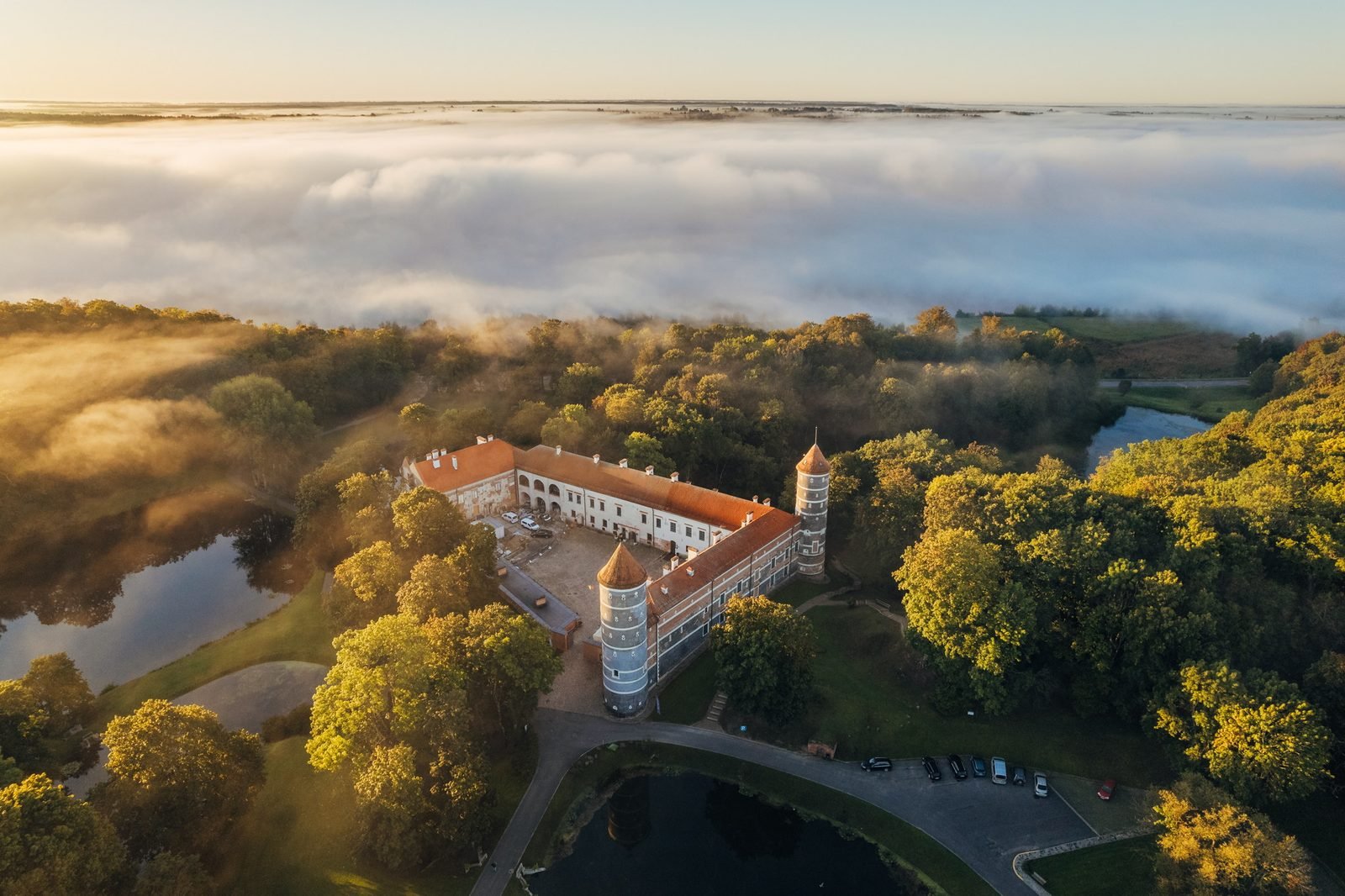Panemunė Castle rising above its park and ponds as morning mist covers the surrounding landscape in 2025